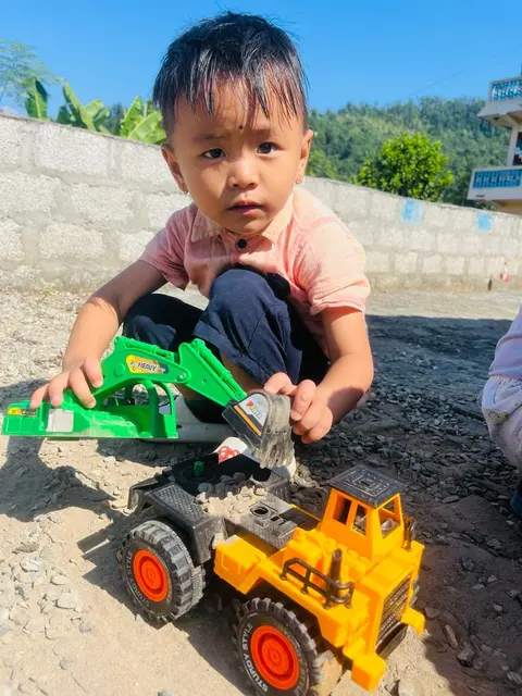 A boy playing with truck toys